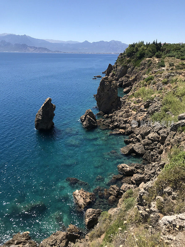 Kumluca Fener Halk Plajı, Muratpasa, Antalya, Turkey. Sea landscape with rocks at the day. Sunny, good weather. Mountain and Turkish city photography, traveling photo for tourism. Beach and water.